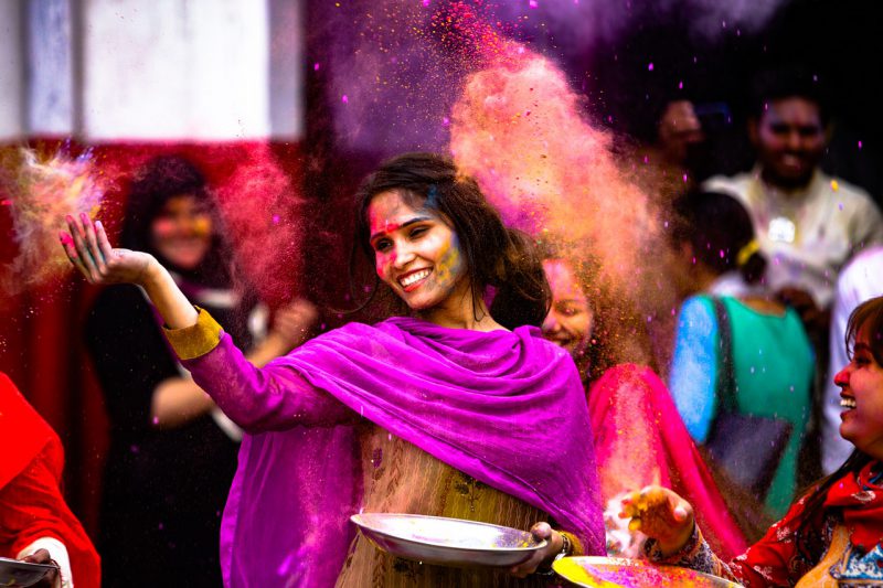 uśmiechnięta hinduska kobieta podrzuca przyprawy