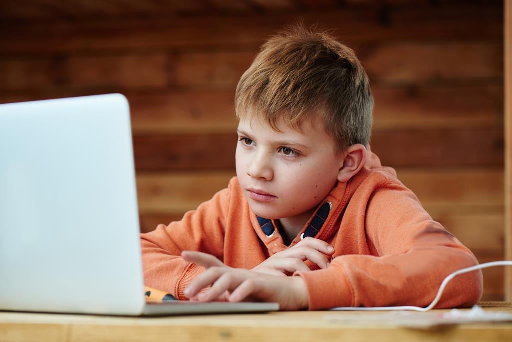 dziecko patrzy w ekran laptopa